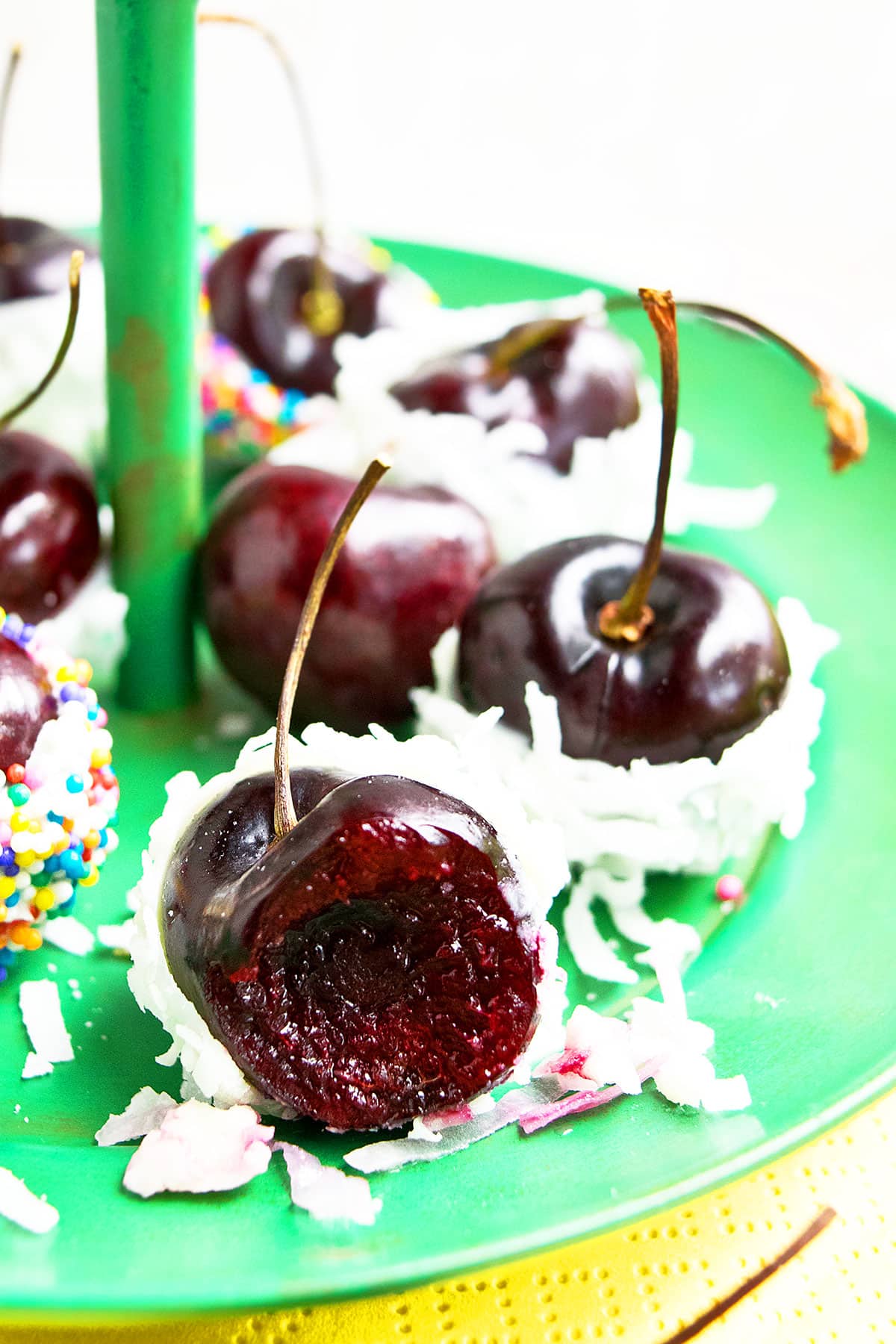Partially Eaten Cherry With White Chocolate and Coconut on Green Dish