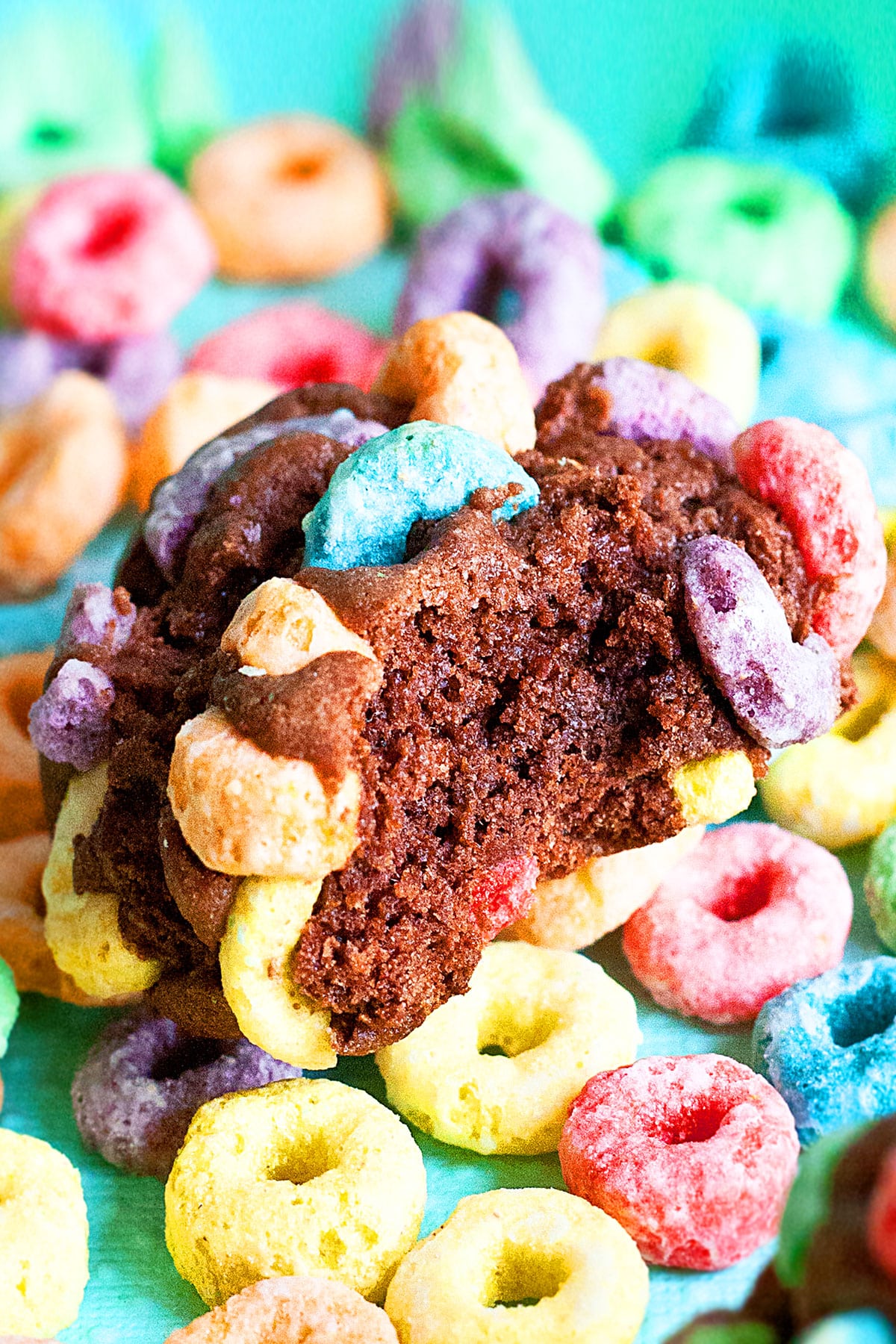 Partially Eaten Chocolate Cookie With Rainbow Froot Loops on a Colorful Background