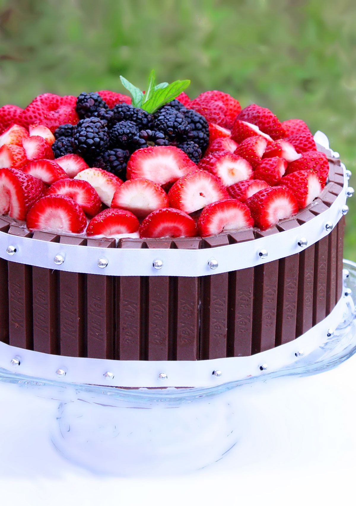 Easy Kit Kat Cake With Strawberries on Glass Cake Stand With Nature Background