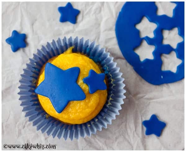 Cupcake Decorated With Blue Fondant Star Cupcake Toppers on Dull Gray Background