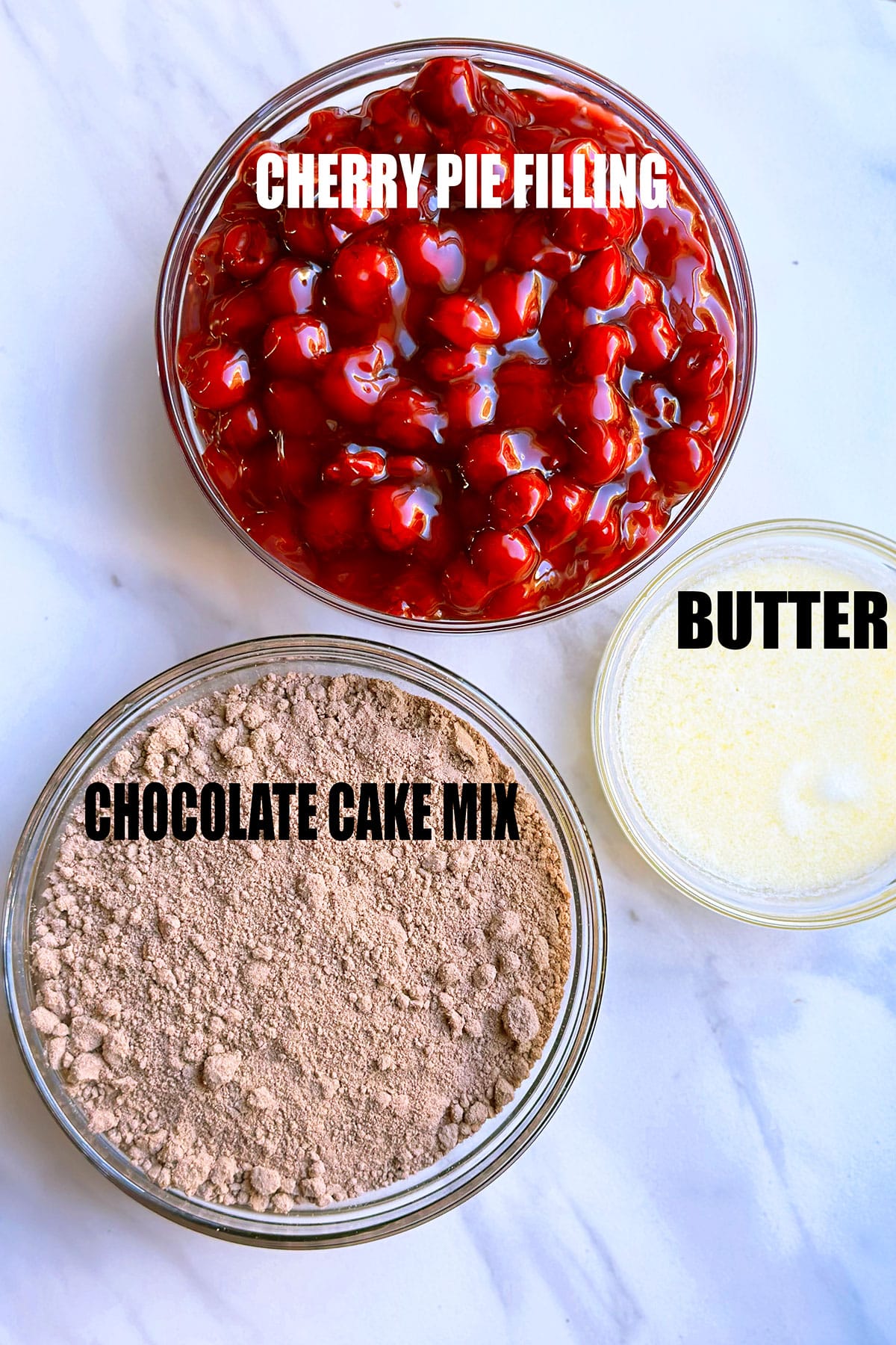 Ingredients For Dump Cake in Glass Bowls on Marble Background