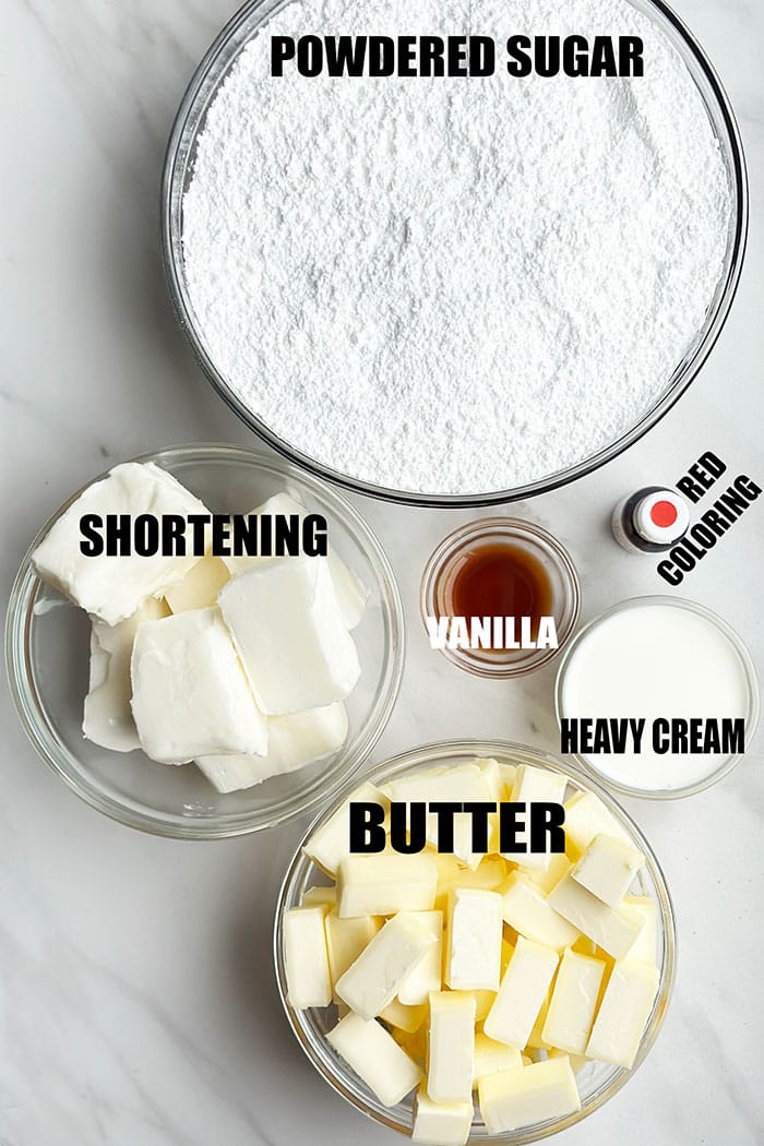 Ingredients For Red Icing in Glass Bowls on Marble Background