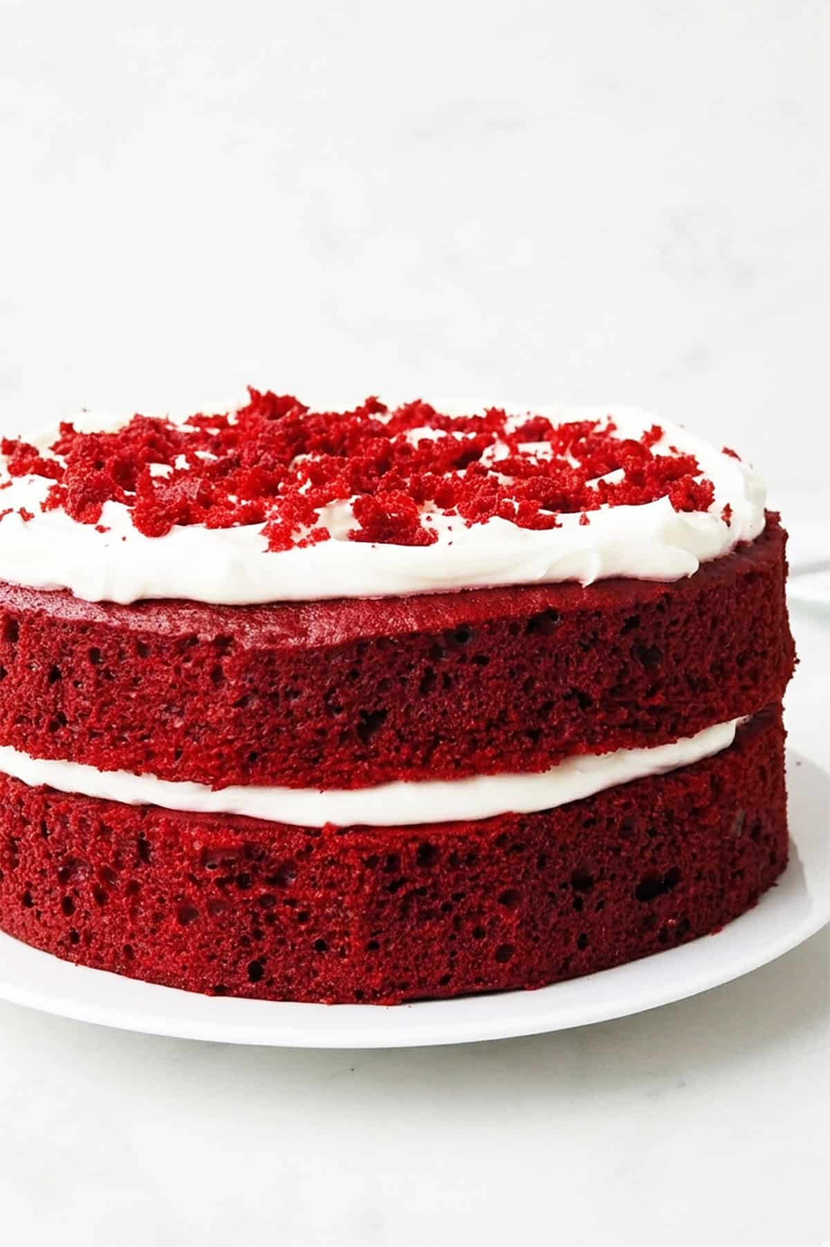 Closeup shot of layer cake on white serving dish. 