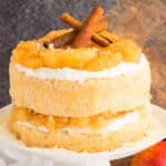 Easy Apple Pie Cake With Cake Mix Filled With Pie Filling and Buttercream Frosting on White Cake Stand.