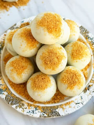 Easy White Chocolate Pumpkin Truffles in Dish With Cookie Crumbs.