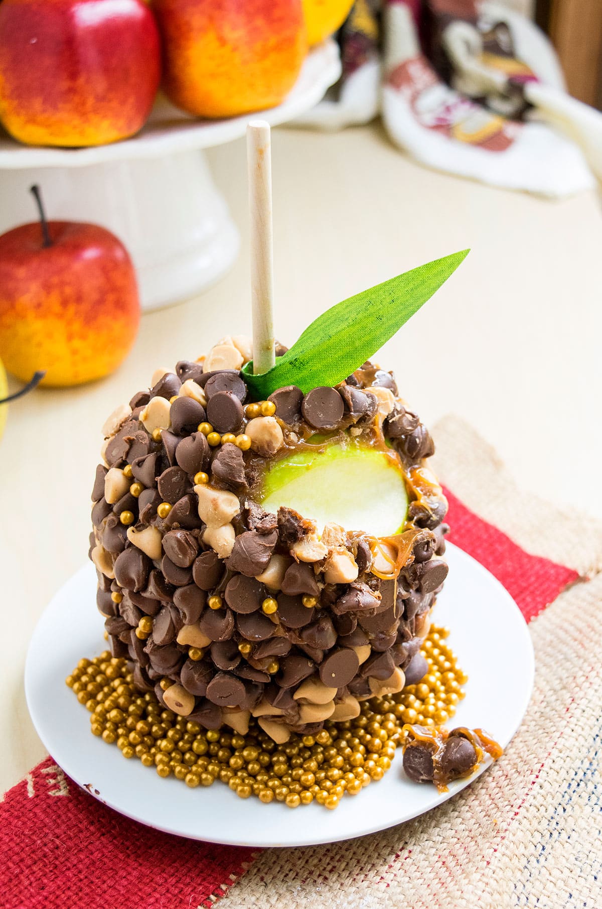 Easy Homemade Chocolate Caramel Apples on White Dish- Partially Eaten.