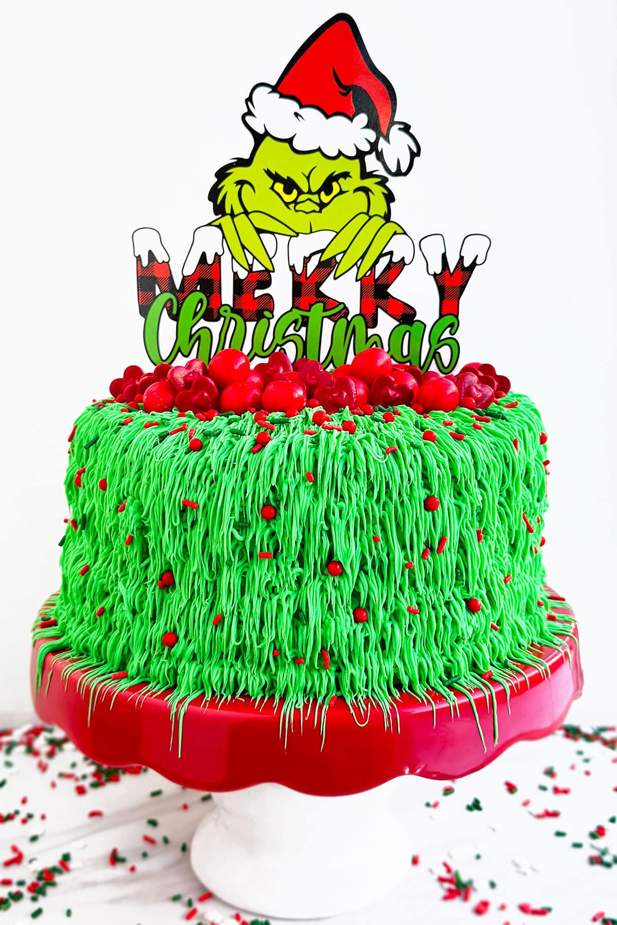 Easy Grinch Cake For Christmas on Red and White Cake Stand. 