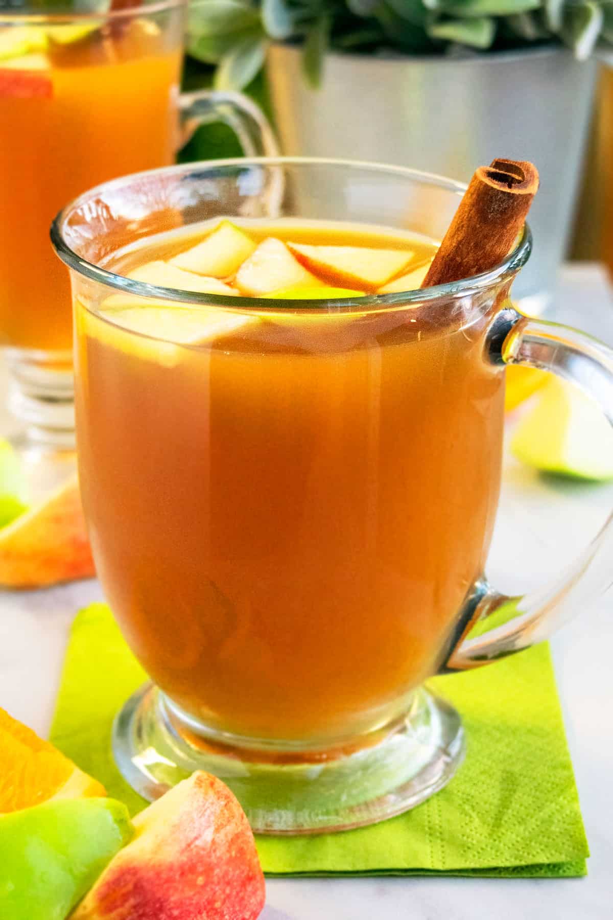 Easy Homemade Slow Cooker Apple Cider in Glass Cup on Green Napkin.