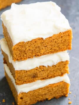 Stack of Easy Pumpkin Bars With Cream Cheese Frosting on Rustic Gray Background
