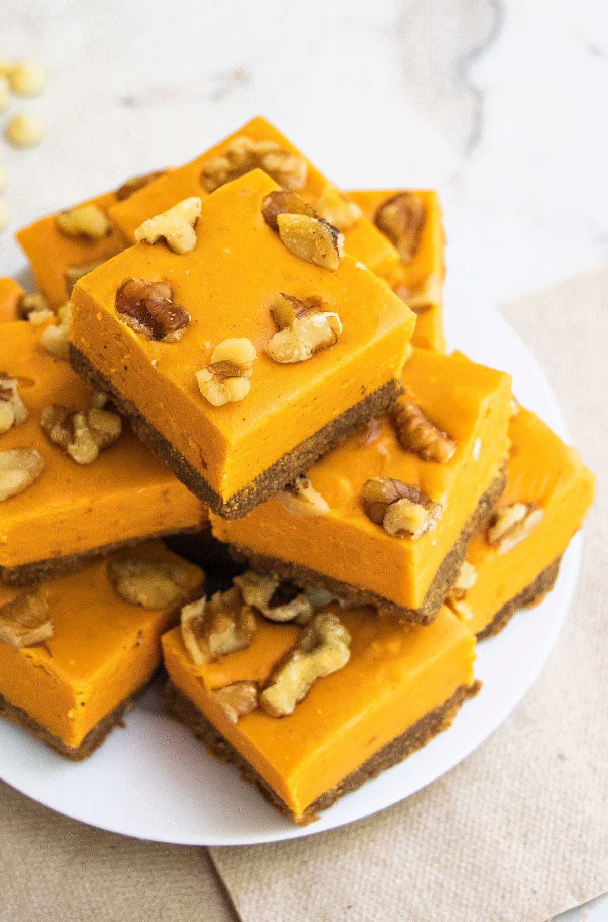 Slices of Microwave Fudge With White Chocolate and Pumpkin Puree on White Dish.