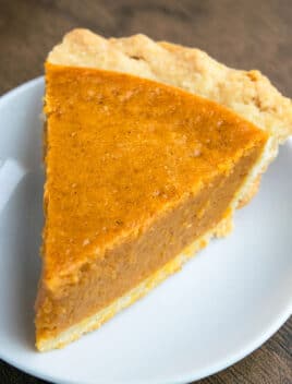 Easy Pumpkin Pie With Flaky Butter Pie Crust on White Dish.