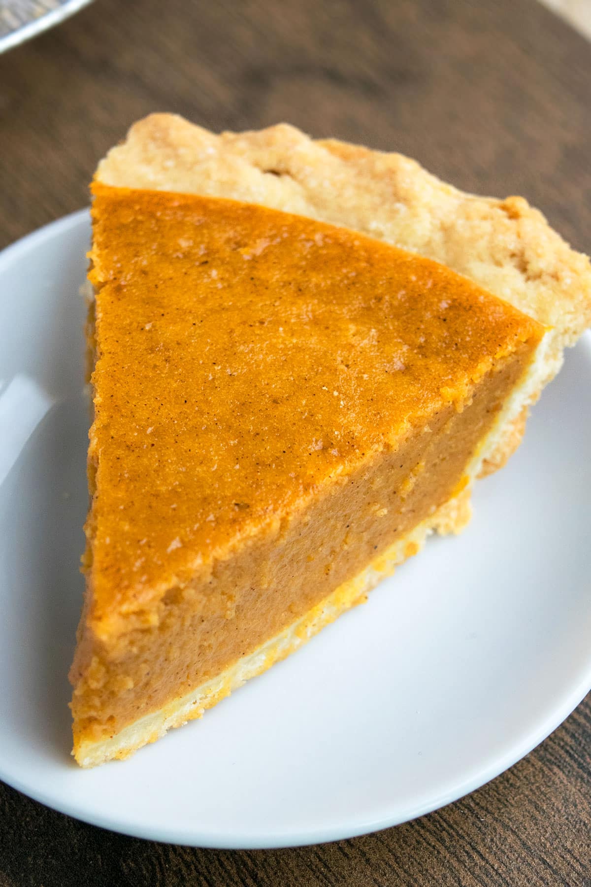 Easy Pumpkin Pie With Flaky Butter Pie Crust on White Dish.