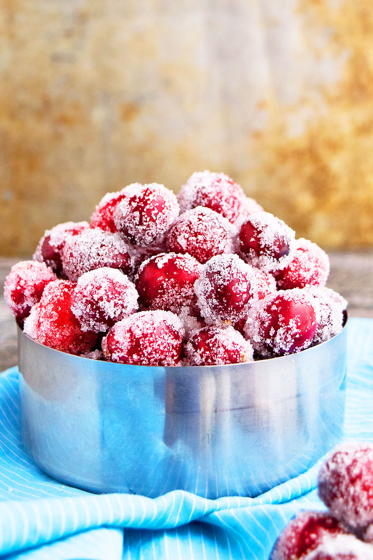 Easy Sugared Cranberries in Metallic Bowl on Blue Cloth. 
