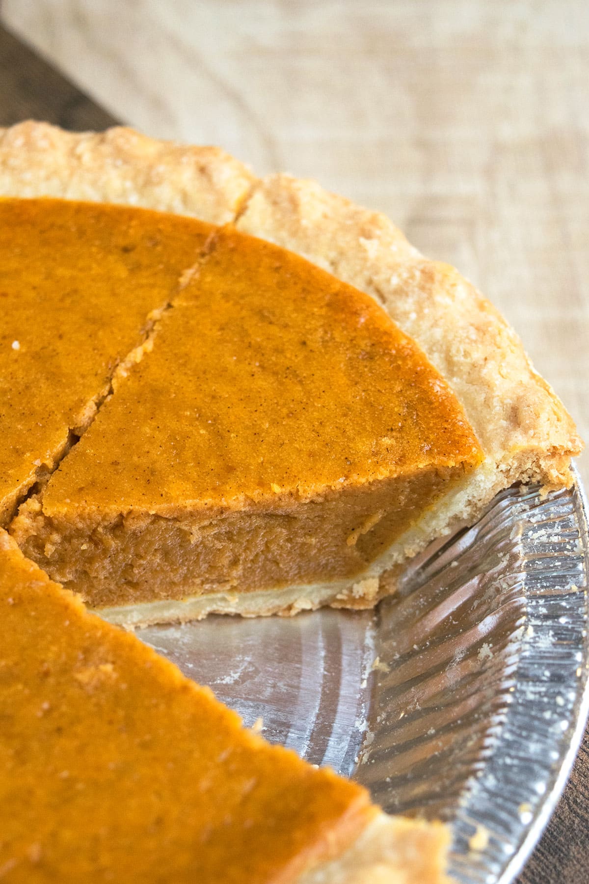 Classic Homemade Pumpkin Pie From Scratch With One Slice Removed in Foil Tray.