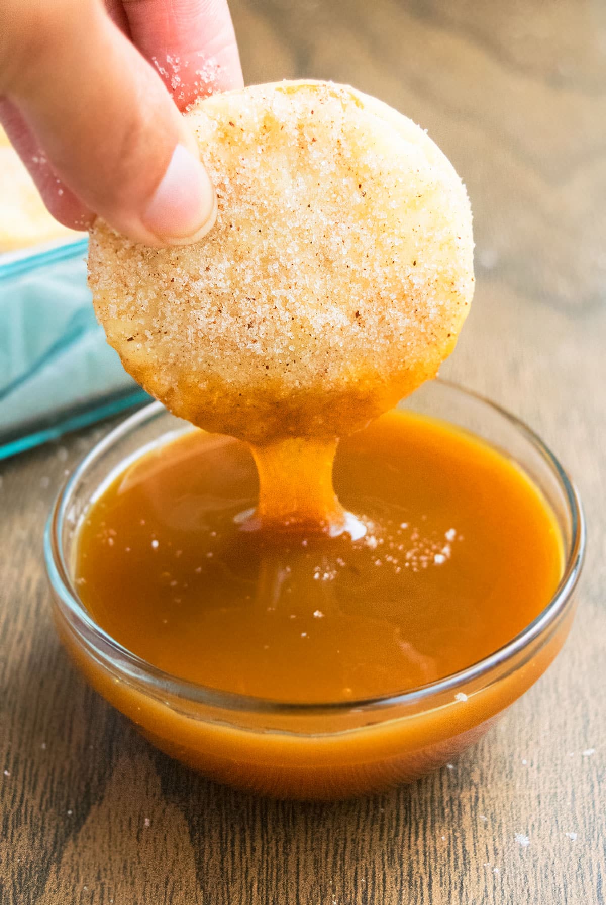 Cinnamon Spiced Pie Crust Cookies Being Dipped in a Bowl of Caramel Sauce