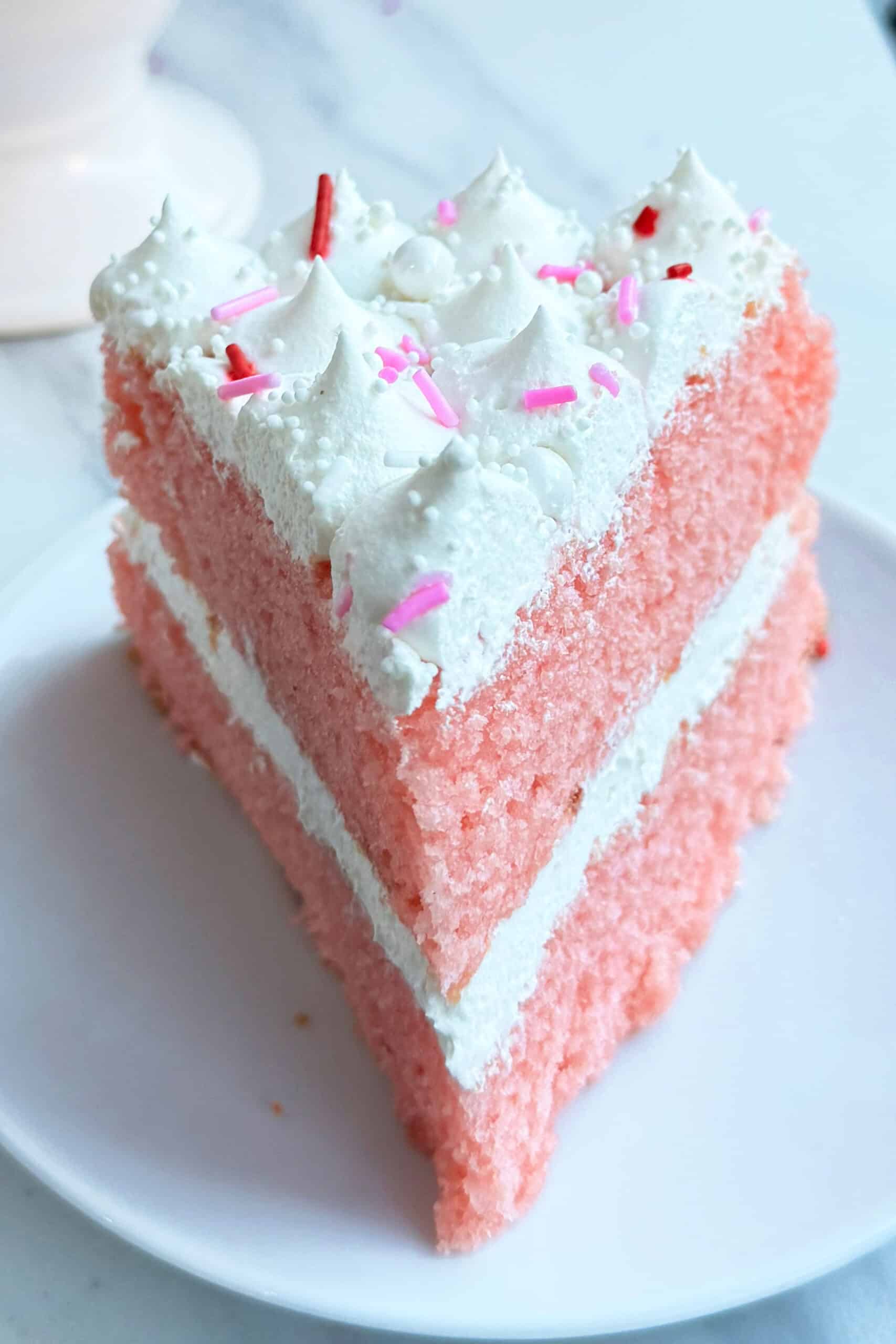 Slice of Strawberry Champagne Layer Cake On White Dish. 