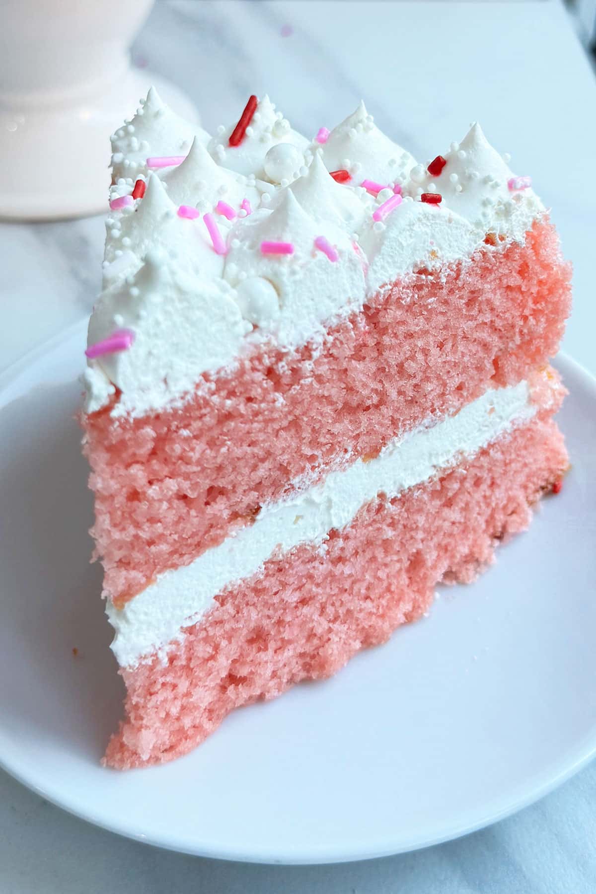 Pink New Year Layer Cake Slice on White Dish. 