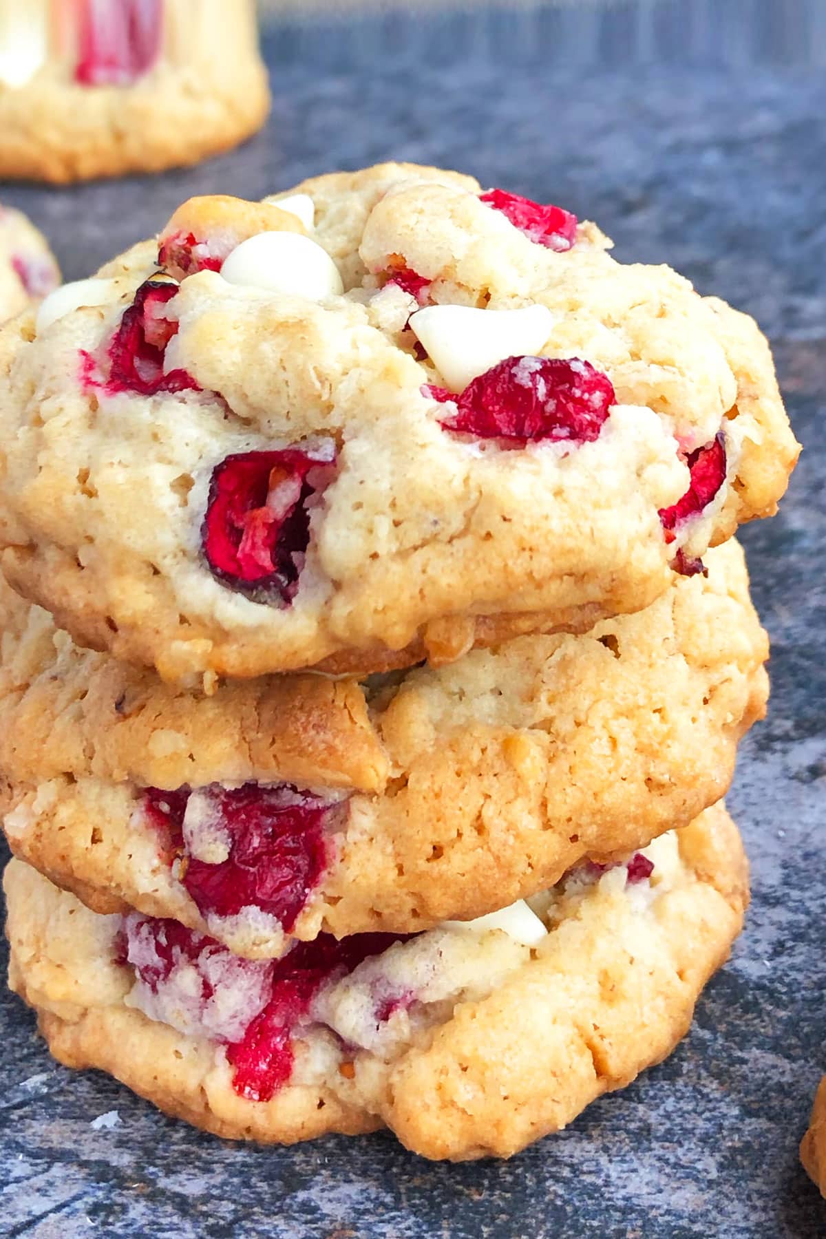 Stack of Fresh Cranberry Cookies With White Chocolate Chips and Oatmeal on Rustic Gray Background.