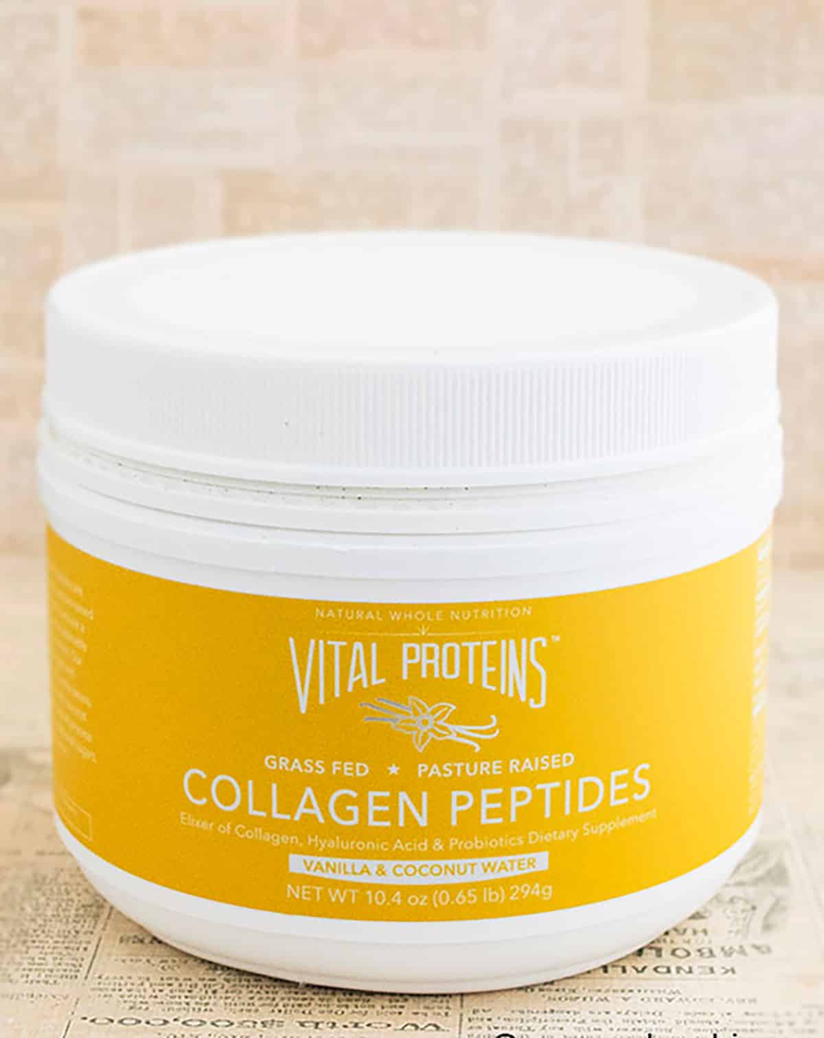 Container of Vital Proteins Collagen Peptides on a Rustic Brown Background.