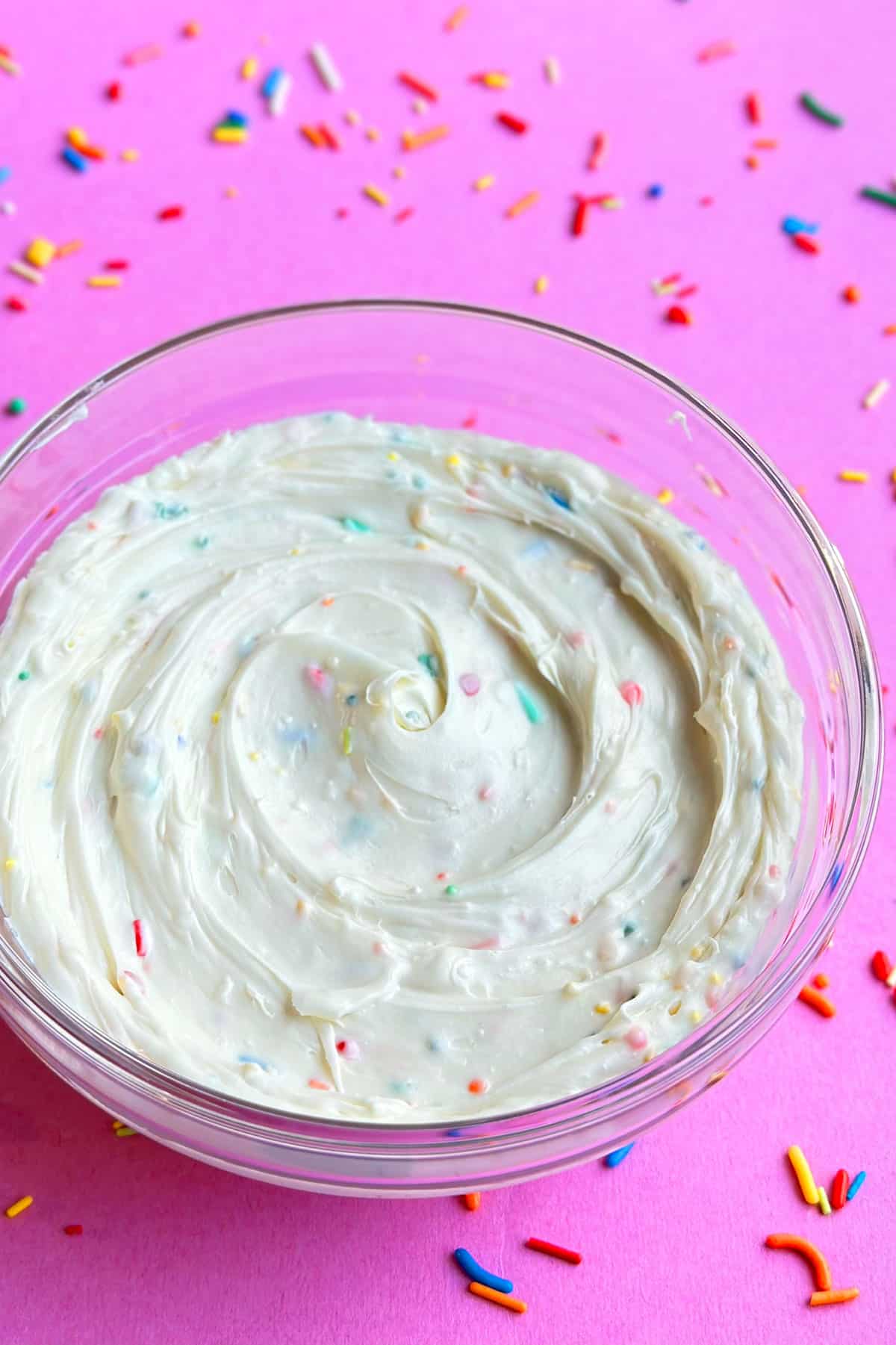Bowl Full of Confetti Icing on Pink Background. 