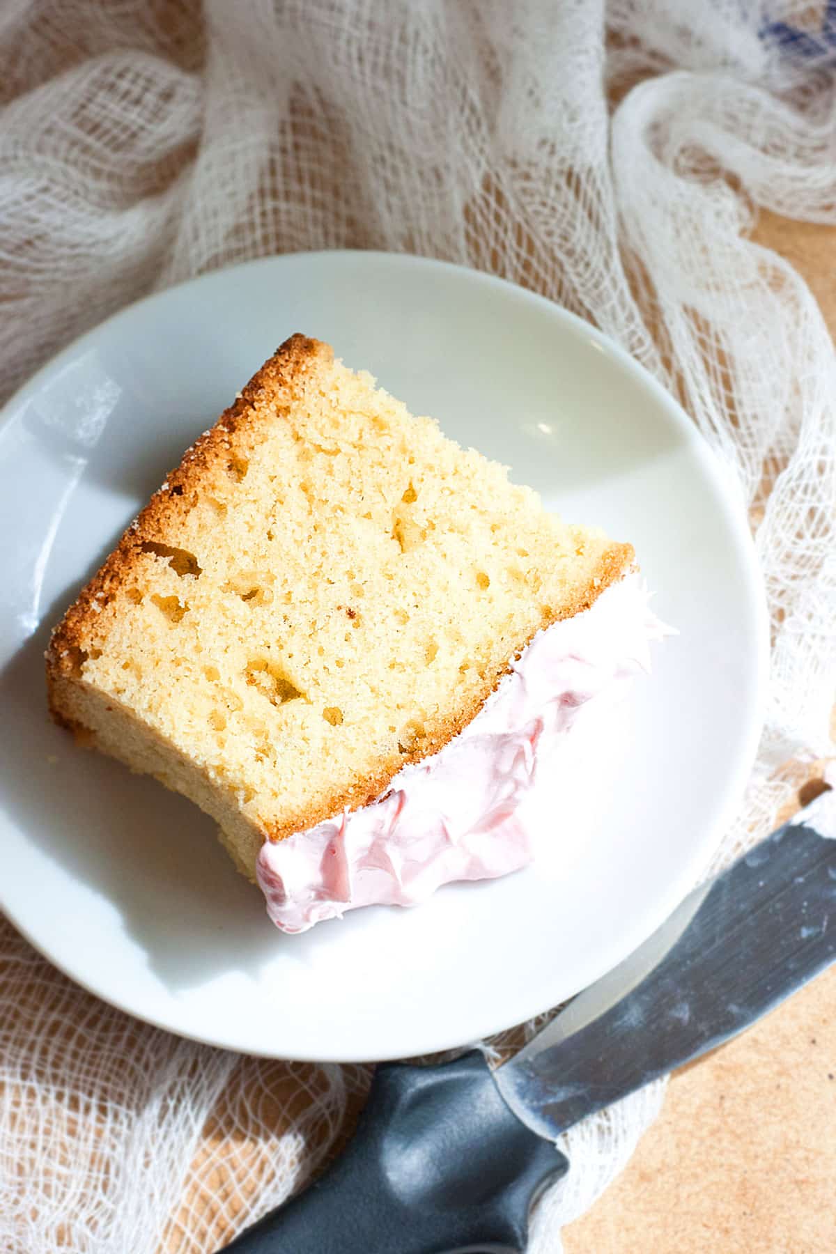 Slice of Pound Cake with Pink Frosting on White Plate.
