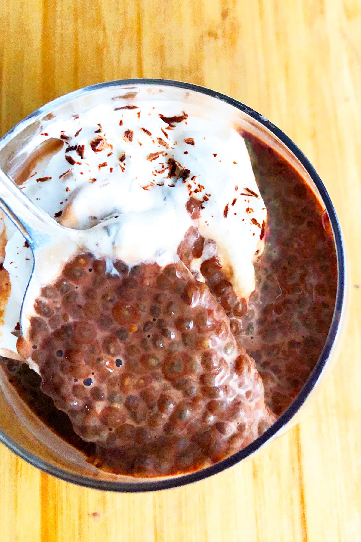 Spoonful of Healthy Chia Pudding With Cocoa Powder in Glass Cup- Closeup Shot. 