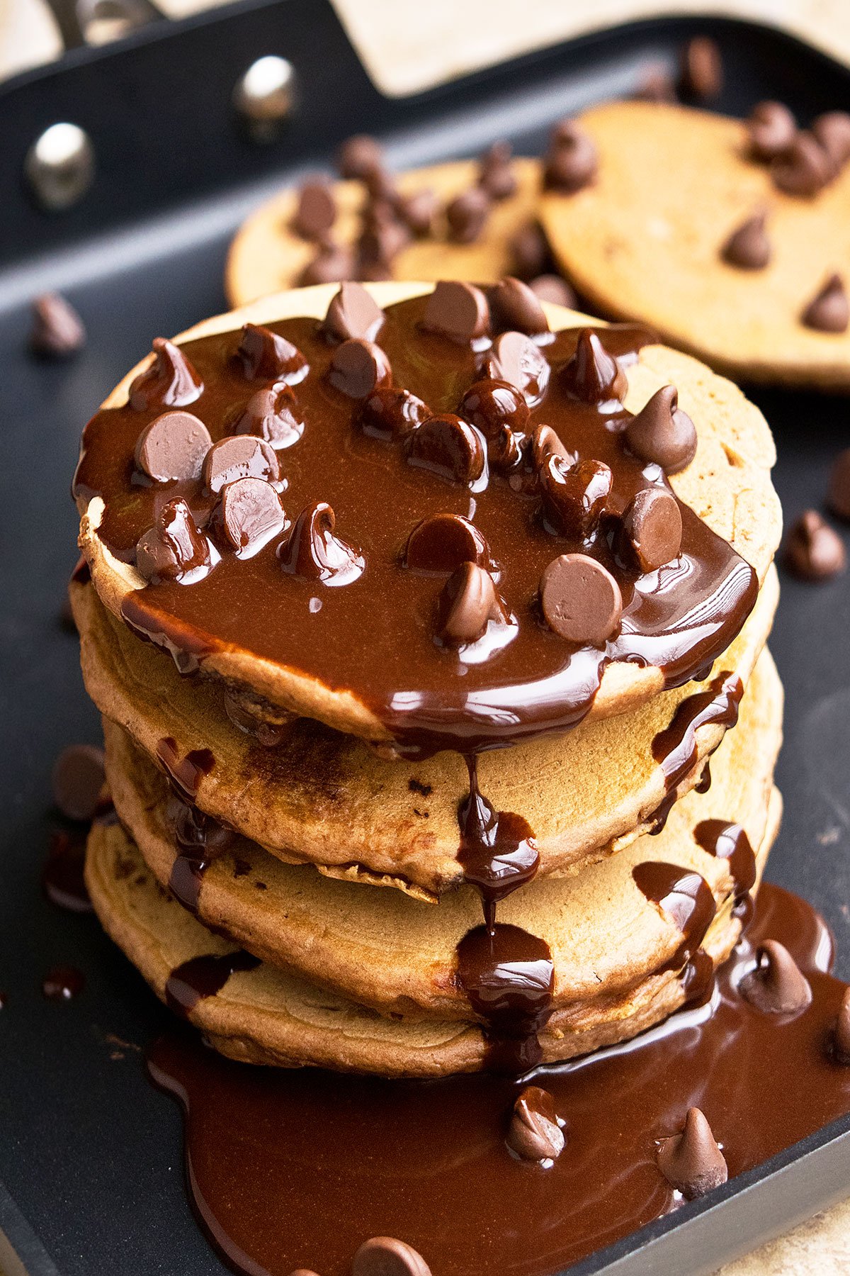 Stack of Easy Coffee Pancakes With Mocha Sauce/ Syrup and Chocolate Chips on Black Pan. 