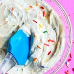 Easy Funfetti Frosting (Sprinkle Frosting) in Glass Bowl on Pink Background.