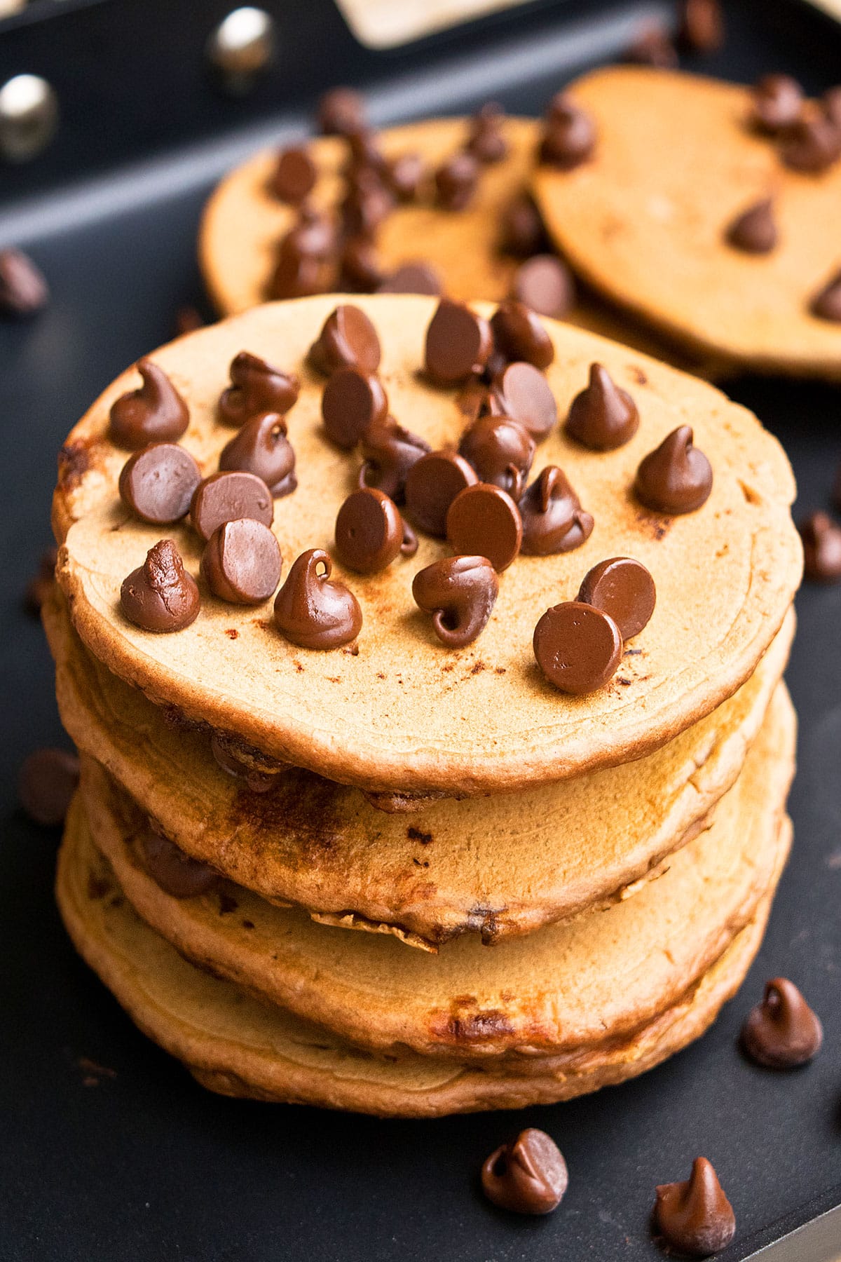 Stack of Mocha Pancakes With Chocolate Chips on Black Pan. 