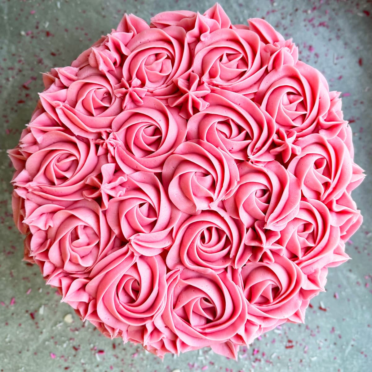 Overhead Shot of Decorated Pink Cake on Rustic Gray Background. 