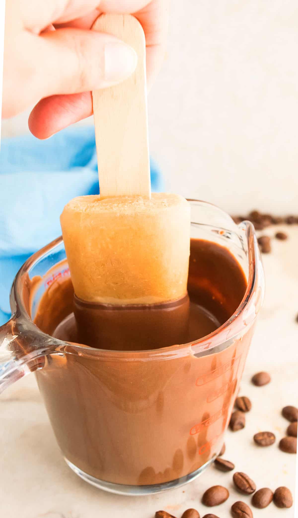 Action Shot of Frozen Popsicle Being Dipped in Cup of Melted Chocolate. 