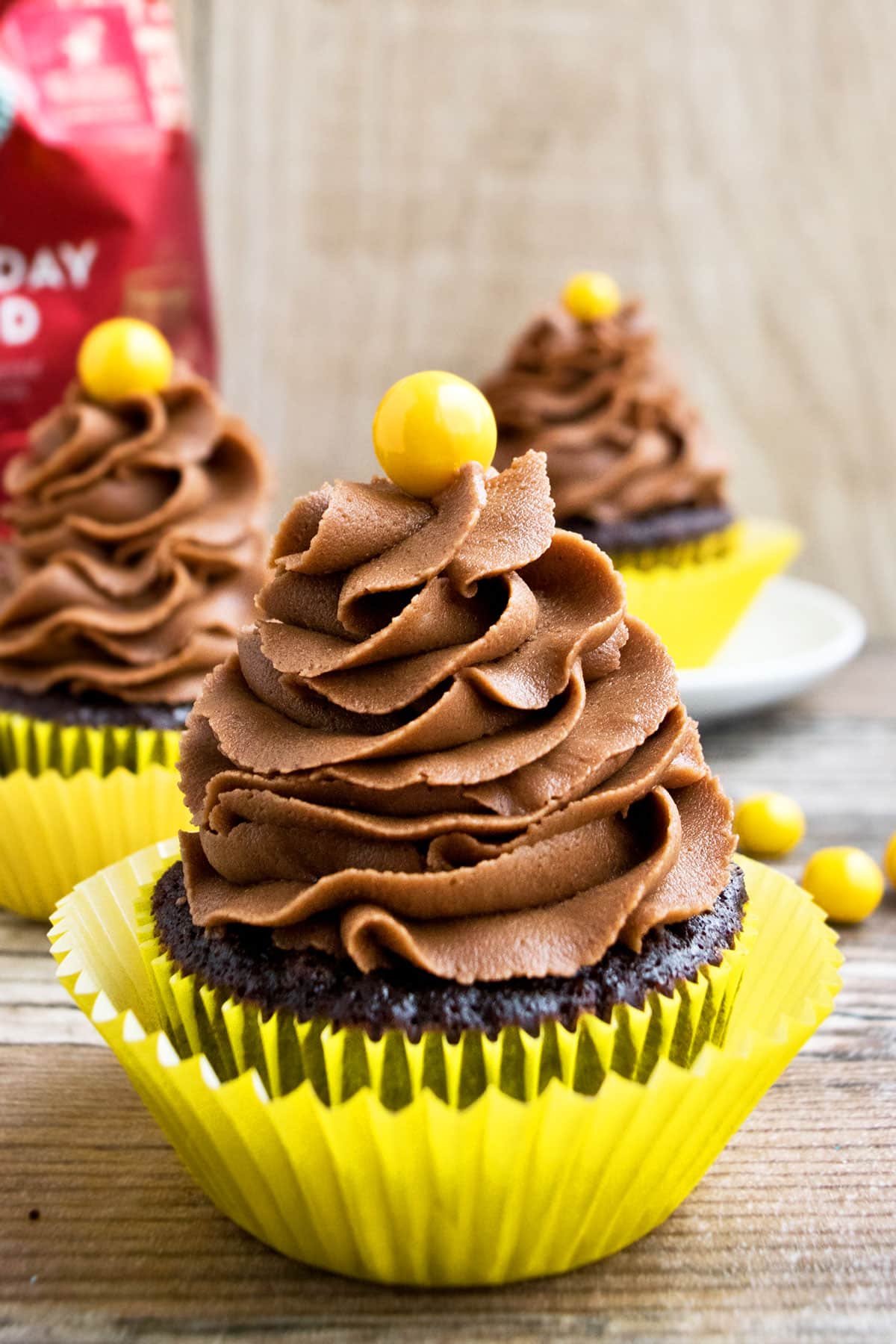 Homemade Mocha Cupcakes in Yellow Liner on Rustic Background. 
