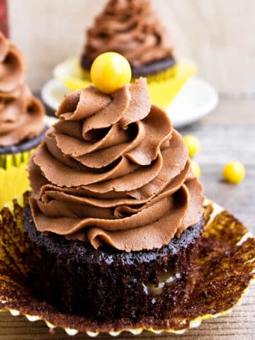 Easy Chocolate Coffee Cupcakes (Mocha Cupcakes) With Liner Partially Removed on Wood Background.