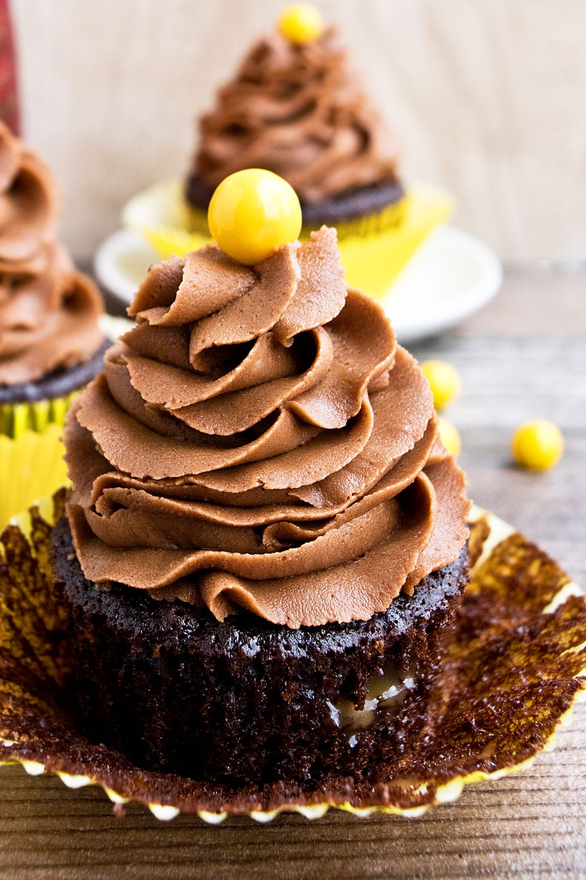 Easy Chocolate Coffee Cupcakes (Mocha Cupcakes) With Liner Partially Removed on Wood Background. 