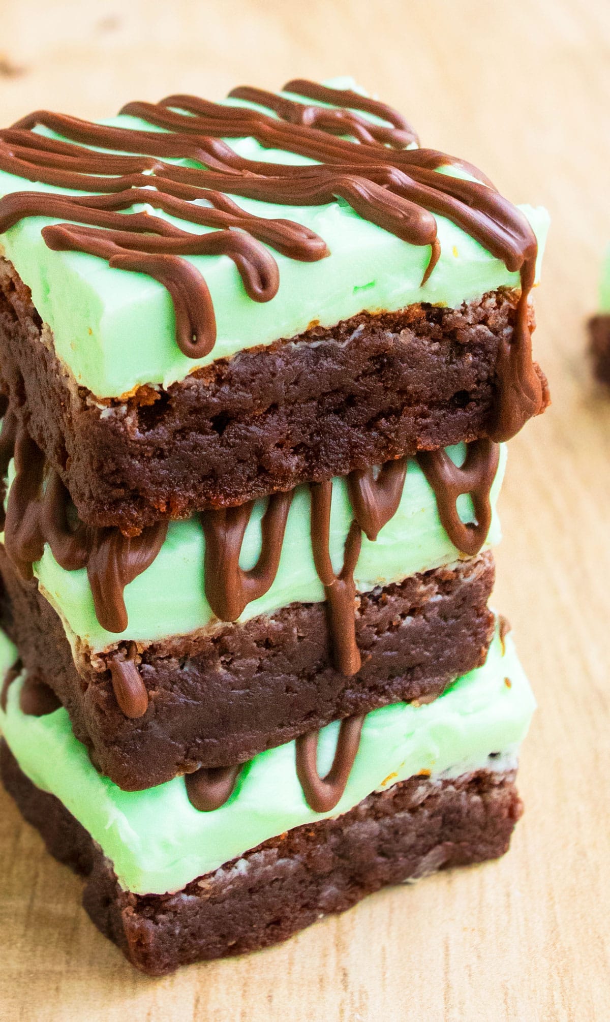 Stack of Chocolate Mint Brownies With Mint Buttercream Frosting on Wood Background. 
