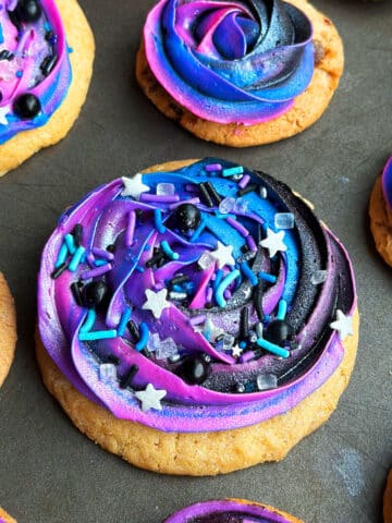 Easy Galaxy Cookies With Buttercream Icing and Sprinkles on Metallic Gray Tray.