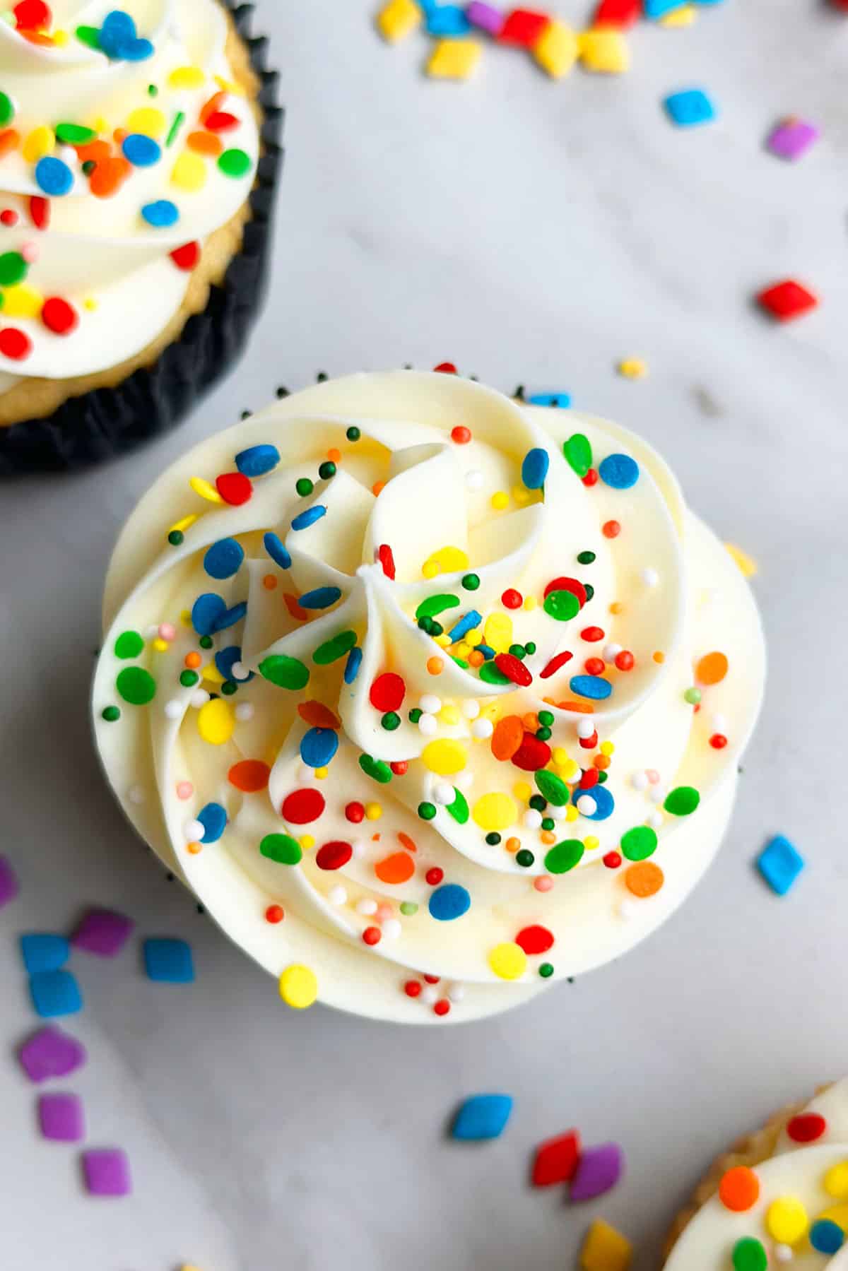 Closeup Shot of Swirl of White Buttercream Icing and Sprinkles. 