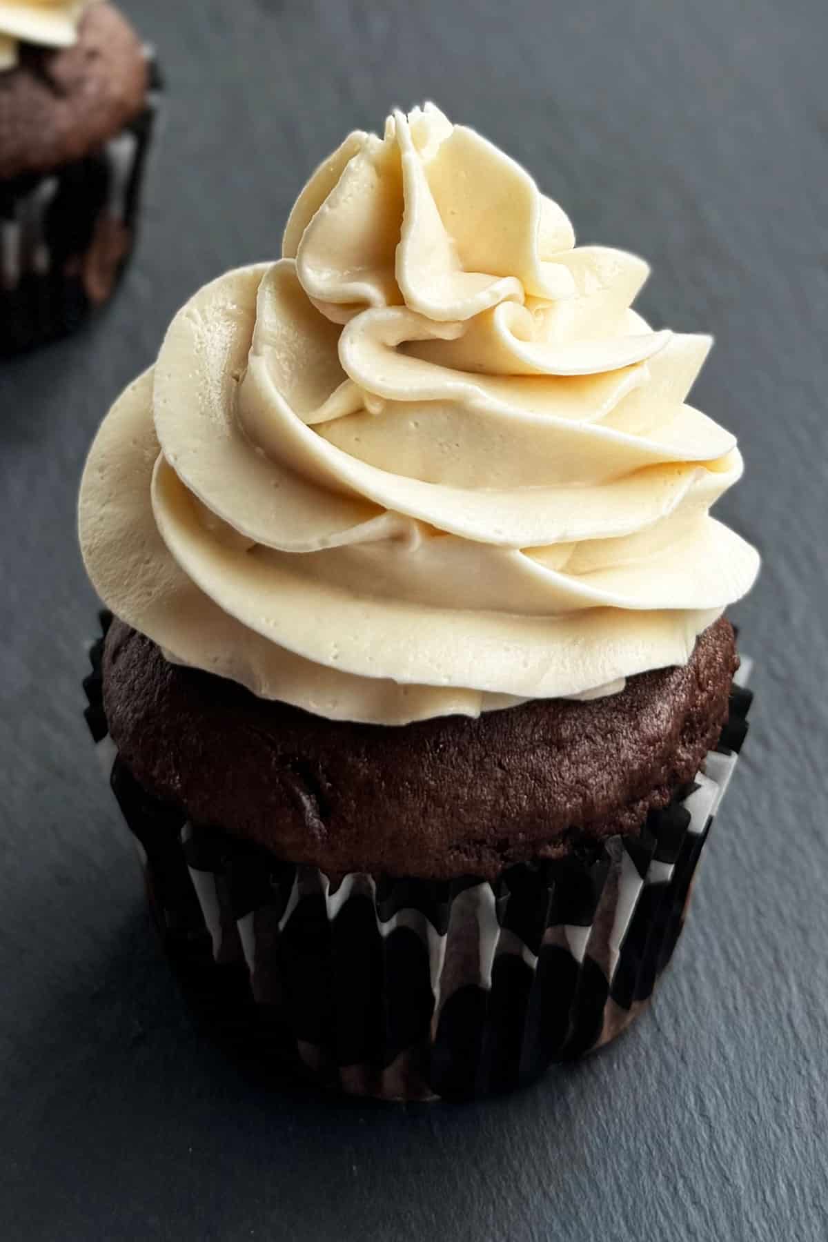 Whipped Frosting Without Powdered Sugar Piped on Top of Chocolate Cupcake. 