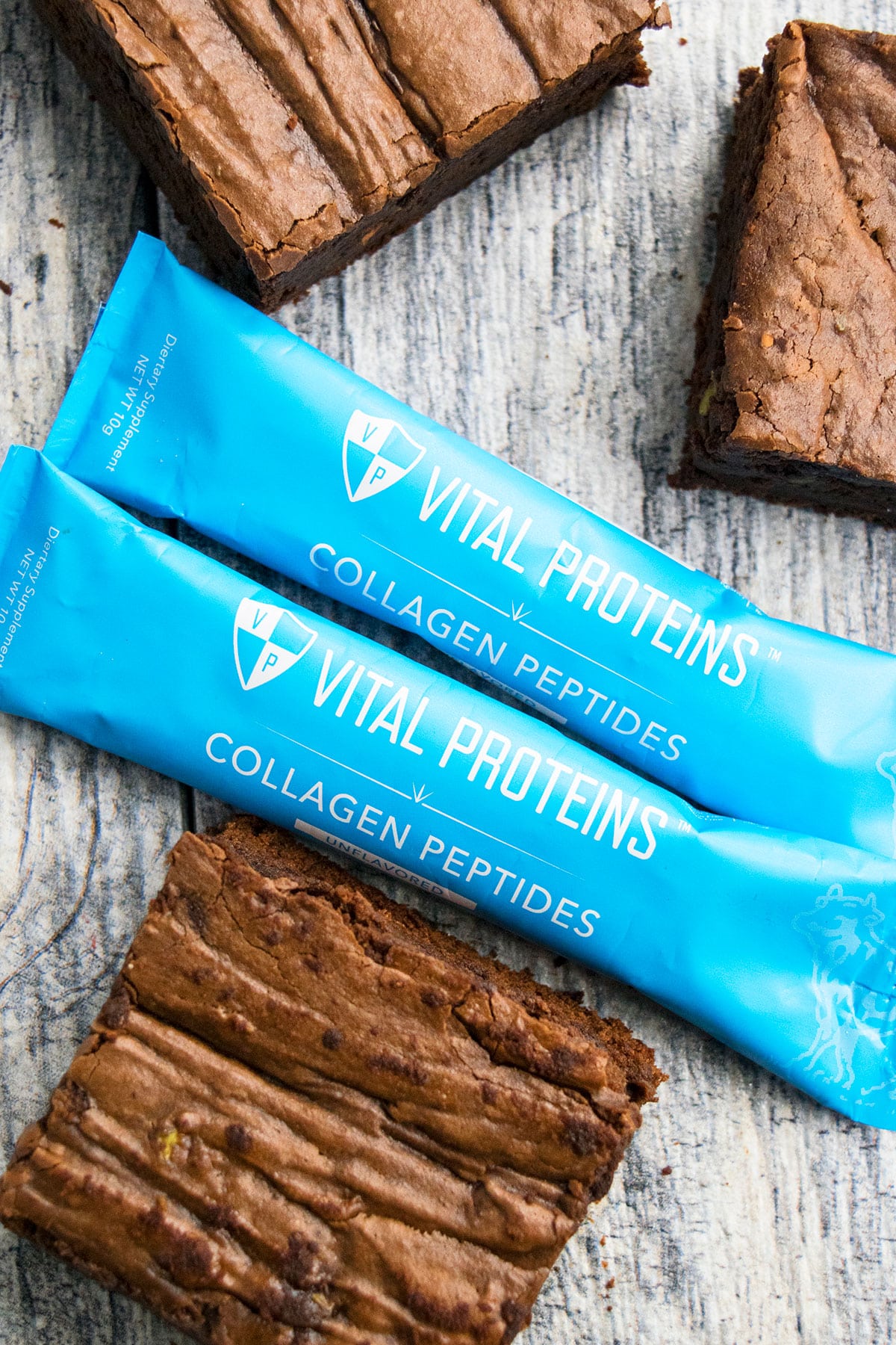 Blue Packets of Vital Proteins Collagen Peptides on Rustic Gray Background. 