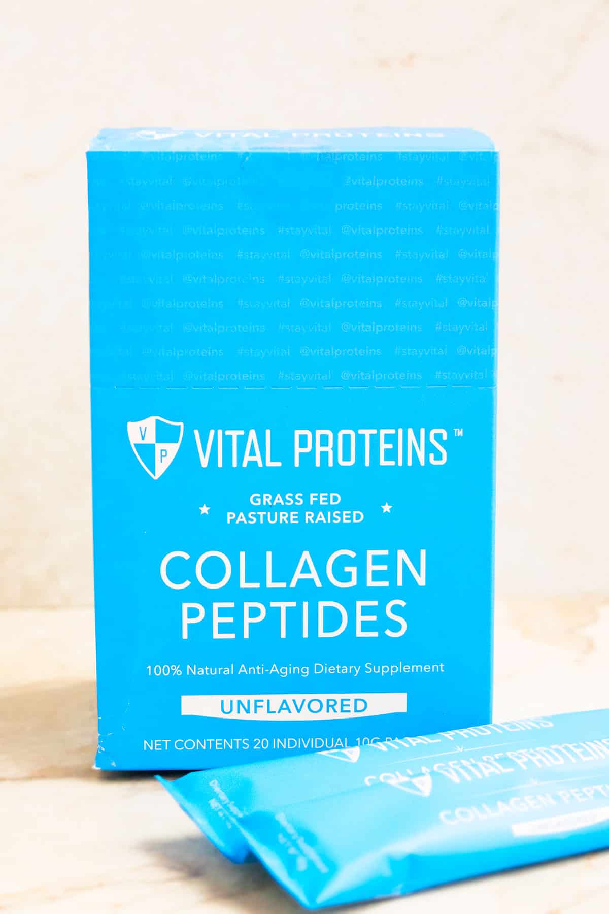 Blue Box of Vital Proteins Collagen Peptides Packets on White Marble Background. 