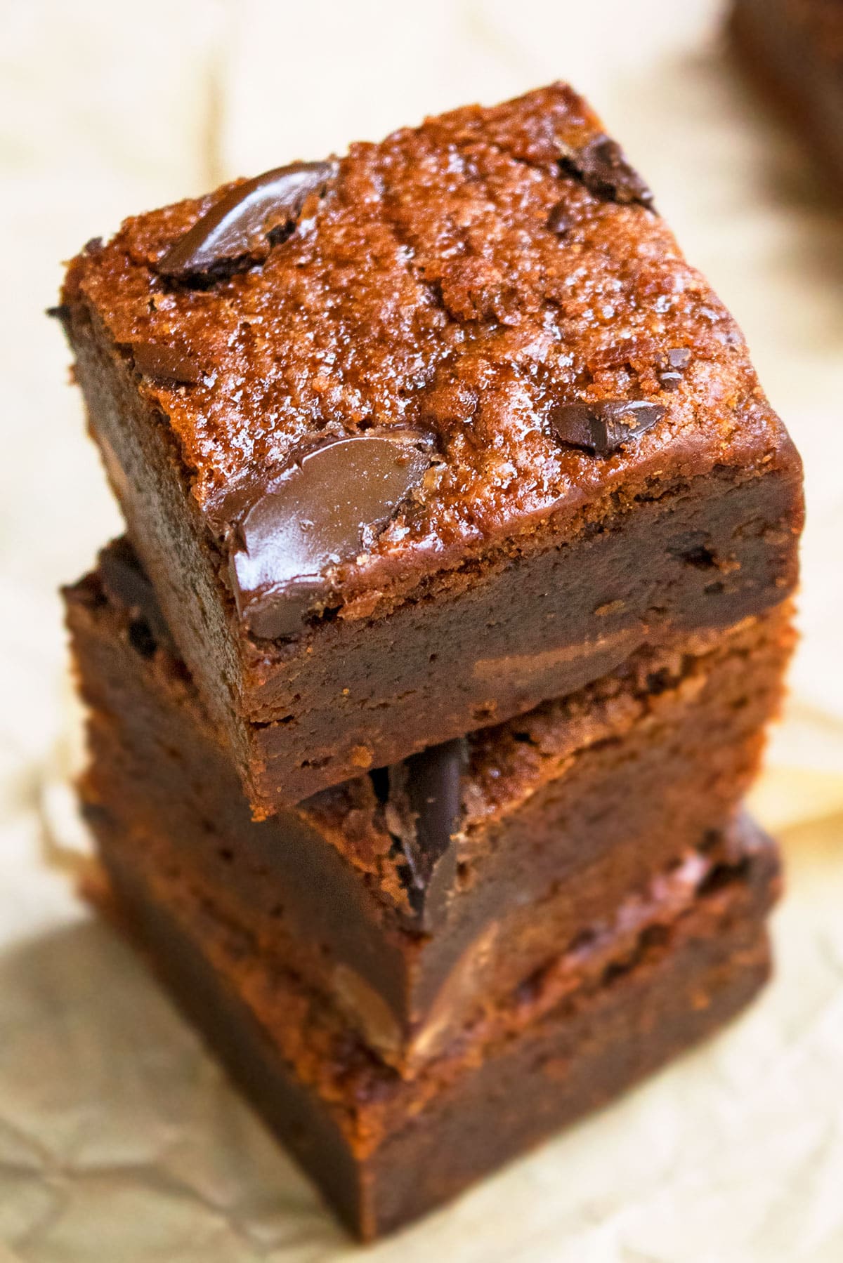 Stack of Fudgy Black Bean Brownies on Brown Parchment Paper. 
