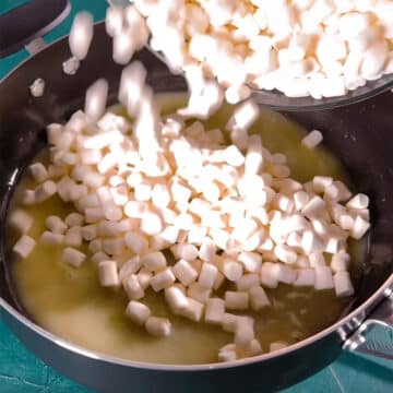 Marshmallows being added to melted butter in nonstick pot. 