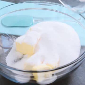 Glass bowl of butter and granulated sugar. 