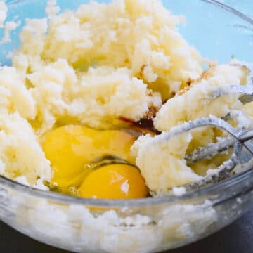 Glass bowl with creamed butter and sugar, eggs and vanilla extract. 