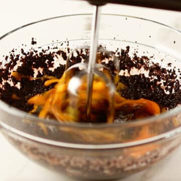 Brownie batter being mixed in a glass bowl. 