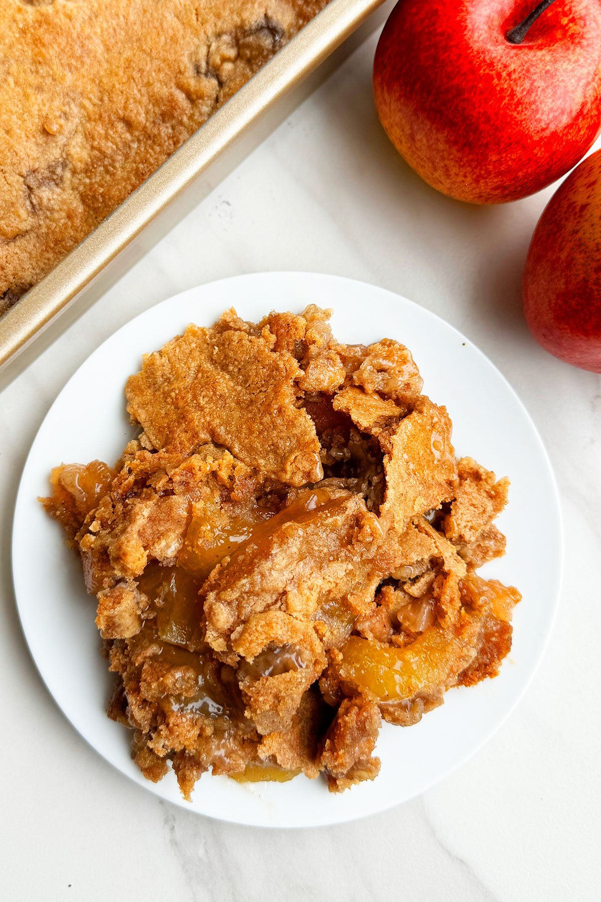 Easy Apple Dump Cake Made With Cake Mix and Pie Filling on White Dish. 