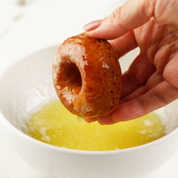 Donuts being dipped in melted butter. 