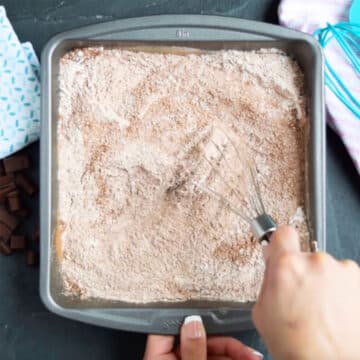 Whisking the dry ingredients in a square cake pan. 