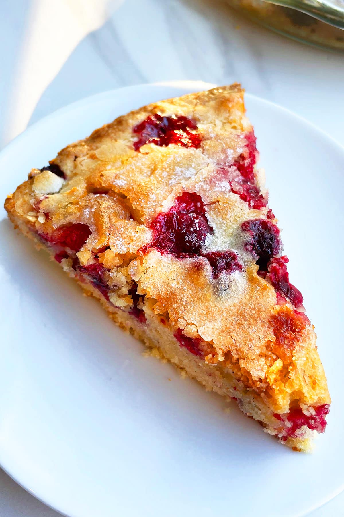 Slice of Crustless Holiday Pie With Fresh Cranberries in White Plate.