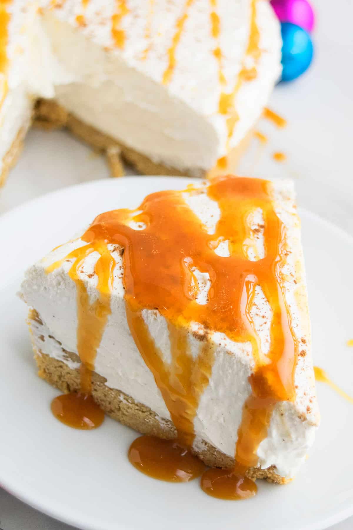 Slice of No Bake Eggnog Cheesecake on White Dish. 